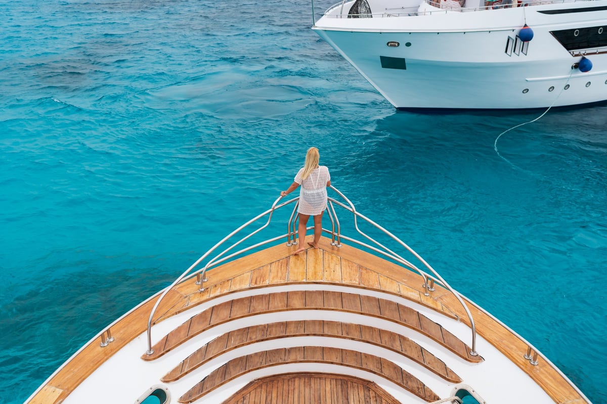 Luxury wooden yacht bow with crystal clear turquoise water