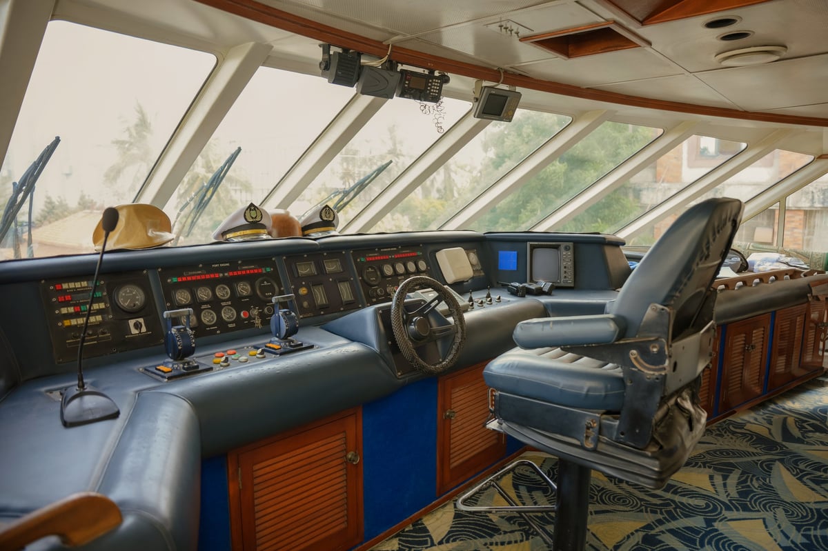 Ship control room with modern navigation equipment and panoramic ocean views